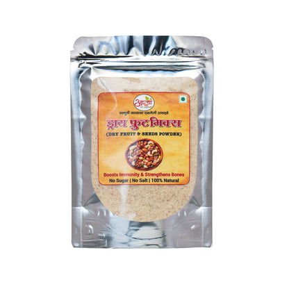 A silver pouch of Dry Fruit Mix Powder with a brown label, featuring mixed nuts and seeds. The label highlights benefits like boosting immunity, strengthening bones, and includes a natural sweetener.